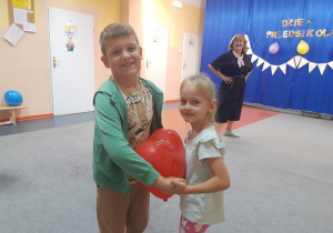 Mikołaj i Viktoriia tańczą z balonem.