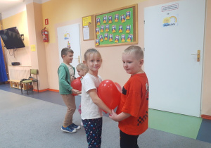 Laura i Oliwier tańczą z balonem.
