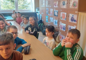 Biedronki razem ze starszymi kolegami siedzą w szkolnych ławkach.