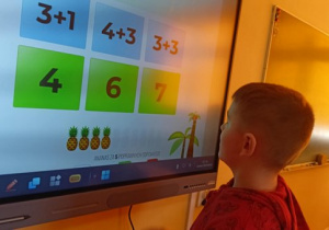 Mikołaj wykonuje zadanie matematyczne.