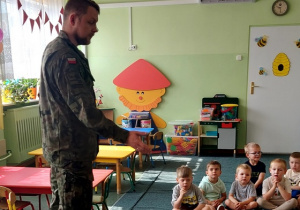 Chłopcy z zainteresowaniem słuchają o pracy w wojsku.