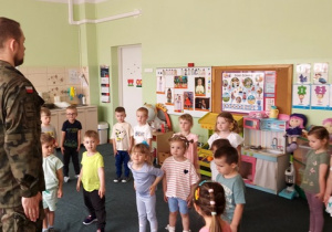 Przedszkolaki przyjmują pozycję "baczność".