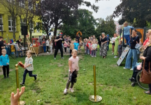 Przedszkolaki biorą udział w biegu na "konikach".