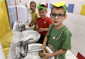 Czarek, Jaś i Michał myją jabłka.