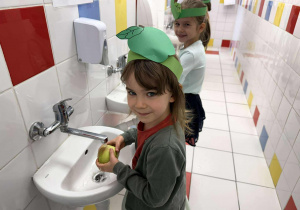 Zosia i Zuzia myją jabłka.