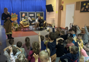 Druhna rozmawia z przedszkolakami na temat bezpieczeństwa i pracy strażaka.