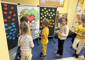 Dzieci przyczepiają gwiazdki ze swoim imieniem.