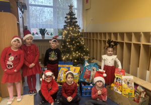 Dzieci ze świątecznymi prezentami dla schroniska dla zwierząt.