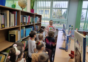Dzieci oglądają księgozbiór biblioteki.