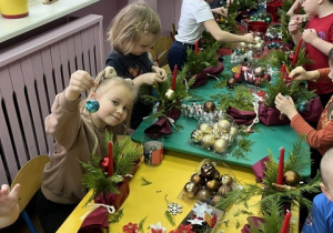 Ewa ozdabia swój stroik bombką.