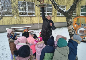 Pani Grażynka zdejmuje karmnik.