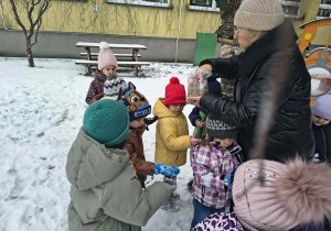 Pani Grażynka opowiada dzieciom o pokarmie dla ptaków.