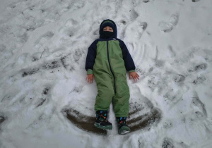 Chłopiec robi aniołka.