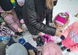 Dzieci z ziarenkami dla ptaszków.