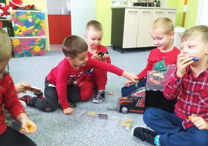 Chłopcy bawią się nowymi zabawkami.