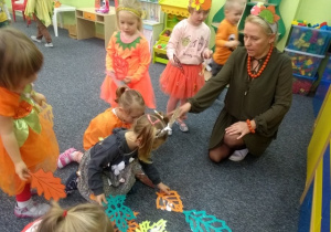 Dzieci układają szal z liści dla Jesieni.