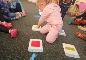 Maja wskazuje żółty trójkąt – dzieci poznają kształty i kolory.