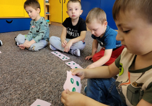 Dzieci liczą kropki na karteczkach.