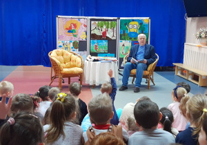 Pan Stanisław czyta dzieciom książeczkę o przygodach Kici Koci.