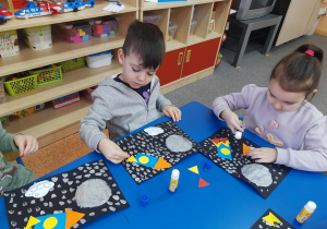 Hubert i Iga układają rakietę z figur geometrycznych.