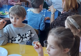 Dzieci jedzą słodki poczęstunek.