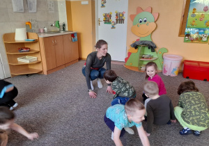 Pani Iza pokazuje sposób wykonania ćwiczenia dzieciom.