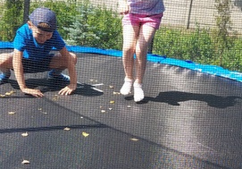 Jaś i Nela skaczą na trampolinie.