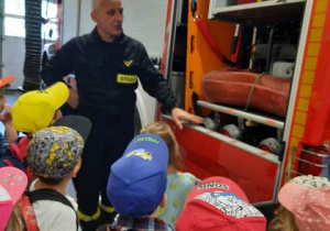 Dzieci oglądają wyposażenie wozu strażackiego.