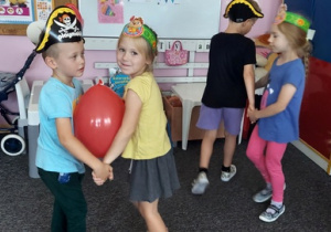 Laura i Miłosz tańczą z balonem.