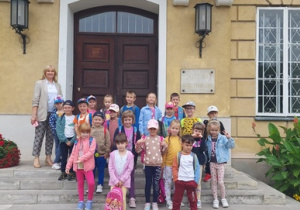 Dzieci stoją przed budynkiem Pałacu Prymasowskiego.