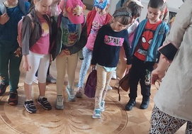 Dzieci oglądają starą mozaikę na podłodze w pałacu.