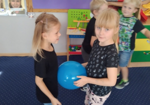 Łucja i Lila tańczą z balonem.