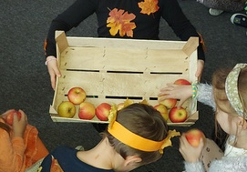 Amelka - Jesienny Skrzat, częstuje dzieci jabłkami.